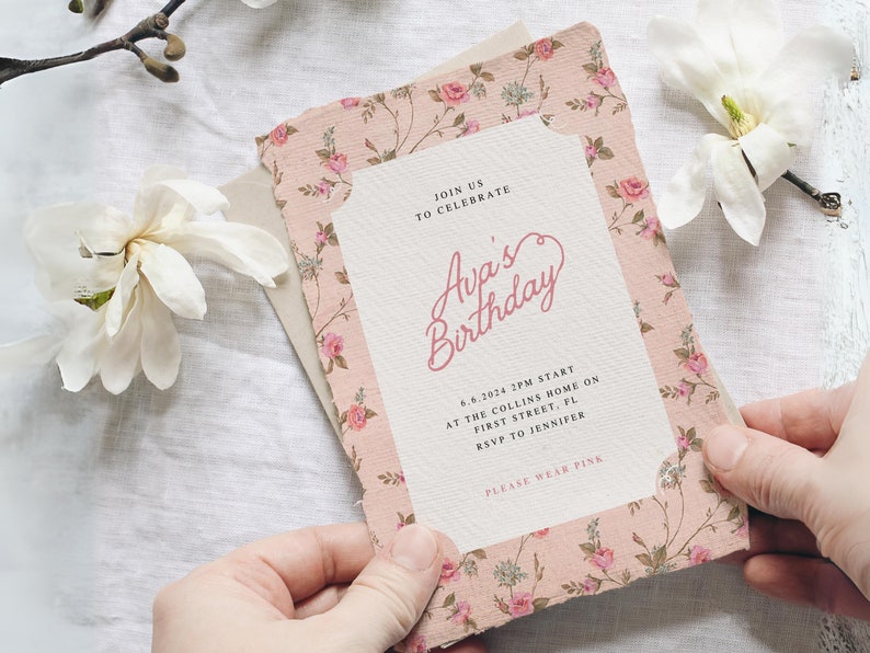 May include: A pink floral patterned invitation card with the text "Join us to celebrate Ava's Birthday" and details for the event. The text "Please wear pink" is at the bottom of the card.
