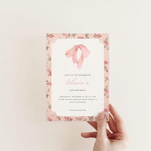 Pu&ograve; includere: Invito floreale rosa con bordo bianco e un fiocco di nastro rosa. L'invito recita "Unisciti a noi per celebrare il 2&deg; compleanno di Olivia".