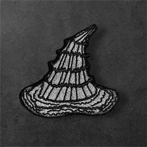May include: A black and white embroidered patch in the shape of a pointed, ruffled hat. The design features a tall, conical crown with horizontal layered sections and a wide, wavy brim, all outlined in black thread with white fill details.