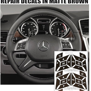 May include: Matte brown steering wheel button repair decals for Mercedes Benz vehicles. The decals are in three shades of brown and feature a rectangular style steering wheel design. The text "Mercedes Benz Rectangle Style Steering" is printed on the decals.