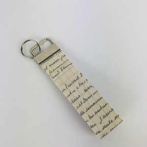 Schlüsselband Creme beige Schrift Brief schwarz Baumwolle Accessoire Schlüsselbund Anhänger Band Schlaufe Geschenk Stoff Muster klein