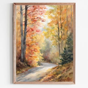 Può includere: Dipinto ad acquerello di una strada tortuosa attraverso una foresta in autunno. Gli alberi mostrano colori vivaci di rosso, arancione e giallo. L'opera d'arte è incorniciata in una cornice di legno marrone chiaro.
