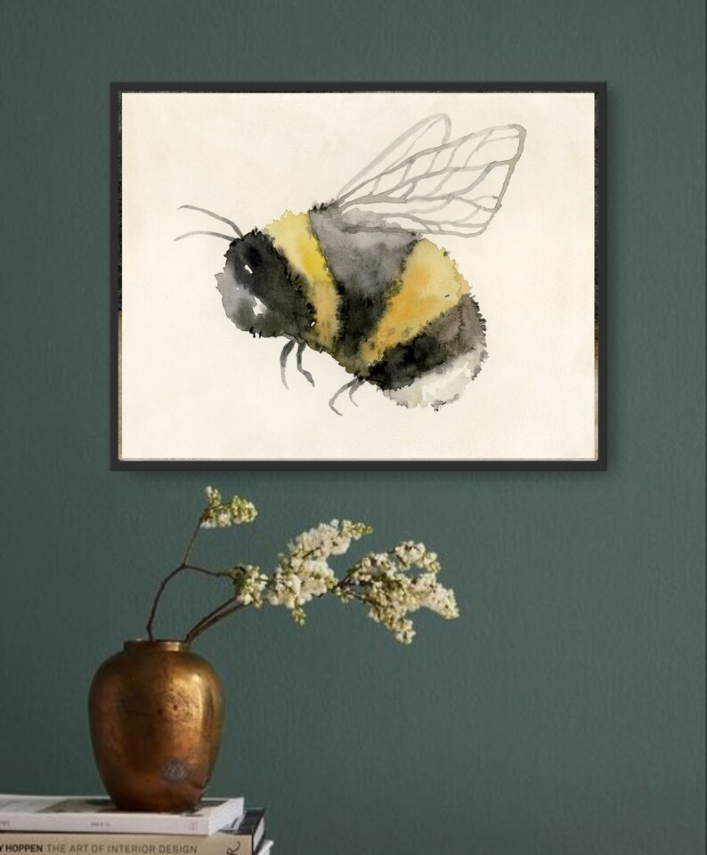 May include: A watercolor painting of a bumblebee with black and yellow stripes and translucent wings. The bee is flying in a white frame against a white background.