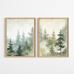 Puede incluir: Un conjunto de dos pinturas de acuarela enmarcadas que representan una escena de bosque brumoso con altos &aacute;rboles de hoja perenne en tonos de verde y marr&oacute;n.