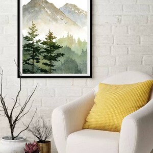 May include: A watercolor painting of a mountain landscape with a forest in the foreground. The mountains are a light gray color with a hint of blue, and the forest is a deep green. The sky is a light blue with a few white clouds.