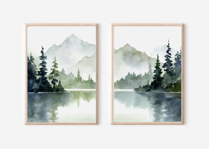 May include: A set of two watercolor paintings depicting a misty mountain lake scene with evergreen trees and a reflection of the mountains in the water.