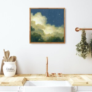 May include: A framed painting of a night sky with clouds and stars. The clouds are a light yellow and the sky is a dark blue. The painting is in a wooden frame.