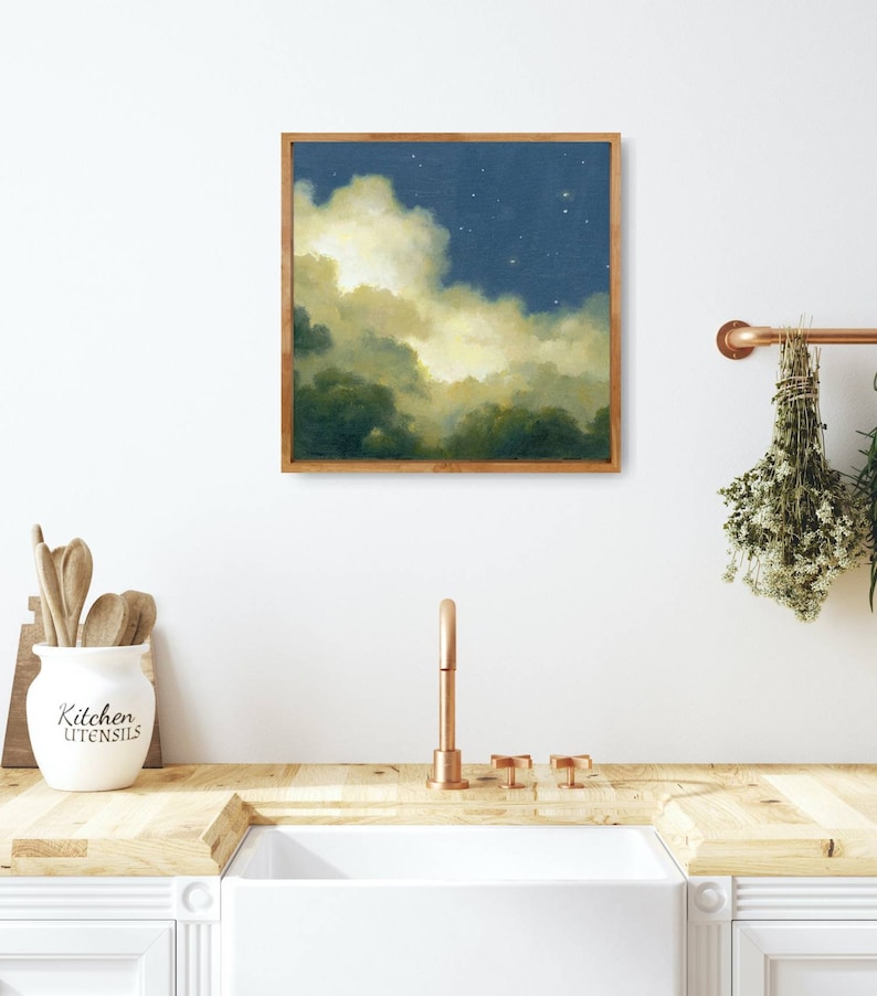 May include: A framed painting of a night sky with clouds and stars. The clouds are a light yellow and the sky is a dark blue. The painting is in a wooden frame.