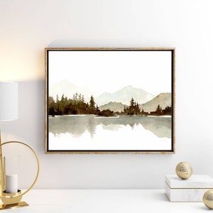 May include: A watercolour painting of a mountain range reflected in a still lake. The mountains are a soft blue and green, and the trees are a dark brown. The water is a light blue and green.