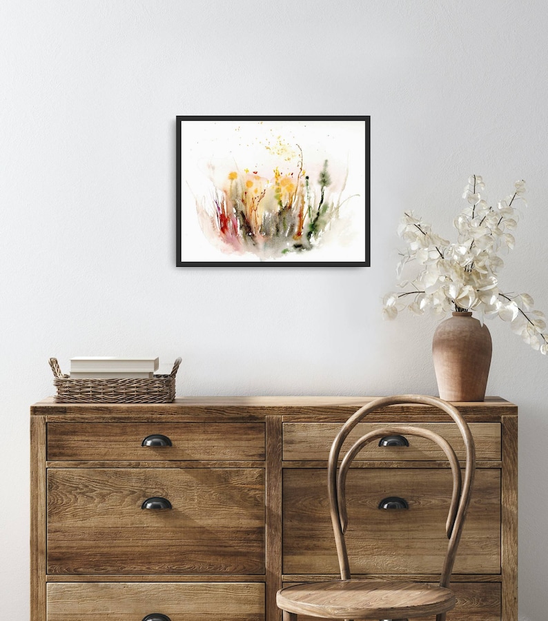 K&ouml;nnte beinhalten: Ein gerahmtes Aquarellbild eines Feldes mit Wildblumen in Gelb-, Orange-, Rot- und Gr&uuml;nt&ouml;nen. Das Bild hat einen wei&szlig;en Hintergrund und ist in Schwarz gerahmt.