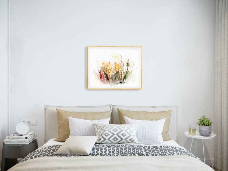 K&ouml;nnte beinhalten: Ein gerahmtes Aquarellbild mit einem farbenfrohen abstrakten Blumendesign mit Spritzern in Rot, Gelb und Gr&uuml;n auf wei&szlig;em Hintergrund.