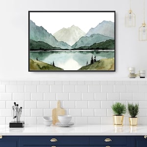 May include: Watercolor painting of a mountain range with a lake in the foreground. The mountains are painted in shades of green and blue, and the lake is a light blue. There are a few trees on the shore of the lake.