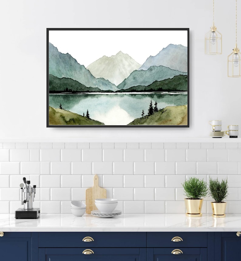 May include: Watercolor painting of a mountain range with a lake in the foreground. The mountains are painted in shades of green and blue, and the lake is a light blue. There are a few trees on the shore of the lake.