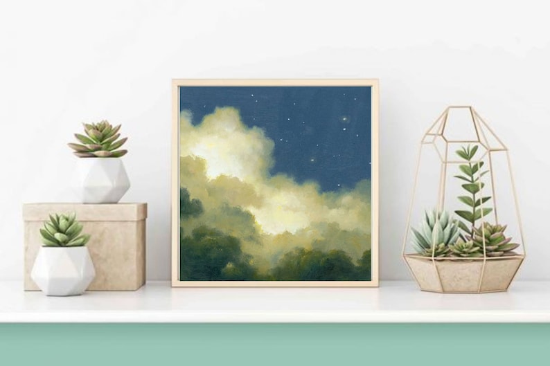 May include: A framed painting of a night sky with clouds and stars. The clouds are a light yellow color and the sky is a dark blue. The painting is in a wooden frame.