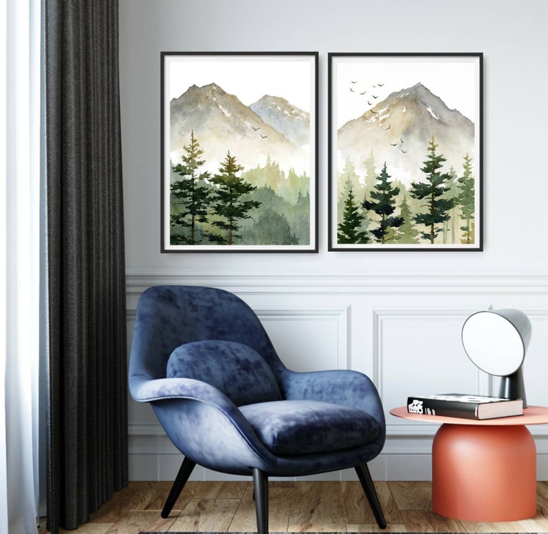 Puede incluir: Dos pinturas de acuarela enmarcadas de una cordillera con un bosque en primer plano. Las pinturas est&aacute;n en tonos de verde, marr&oacute;n y blanco. Las pinturas est&aacute;n colgadas en una pared blanca.