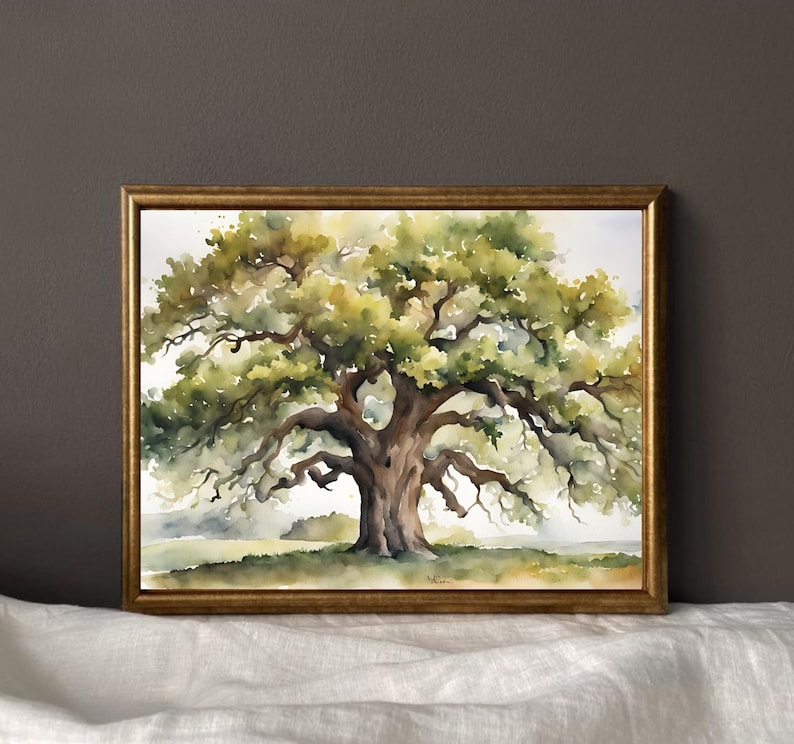 May include: Watercolor painting of a large oak tree with a wide canopy of green and yellow leaves. The tree's trunk and branches are brown. The artwork is framed in a gold-colored frame, set against a neutral background.