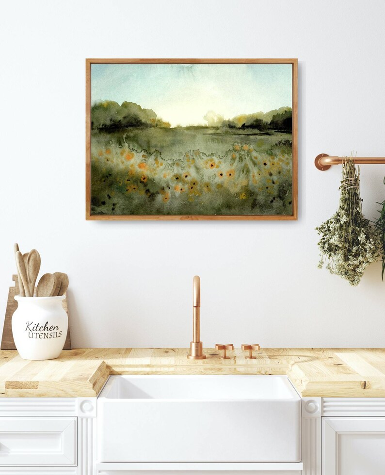 May include: A framed watercolor painting of a landscape with a field of yellow flowers in the foreground and a hazy blue sky in the background.