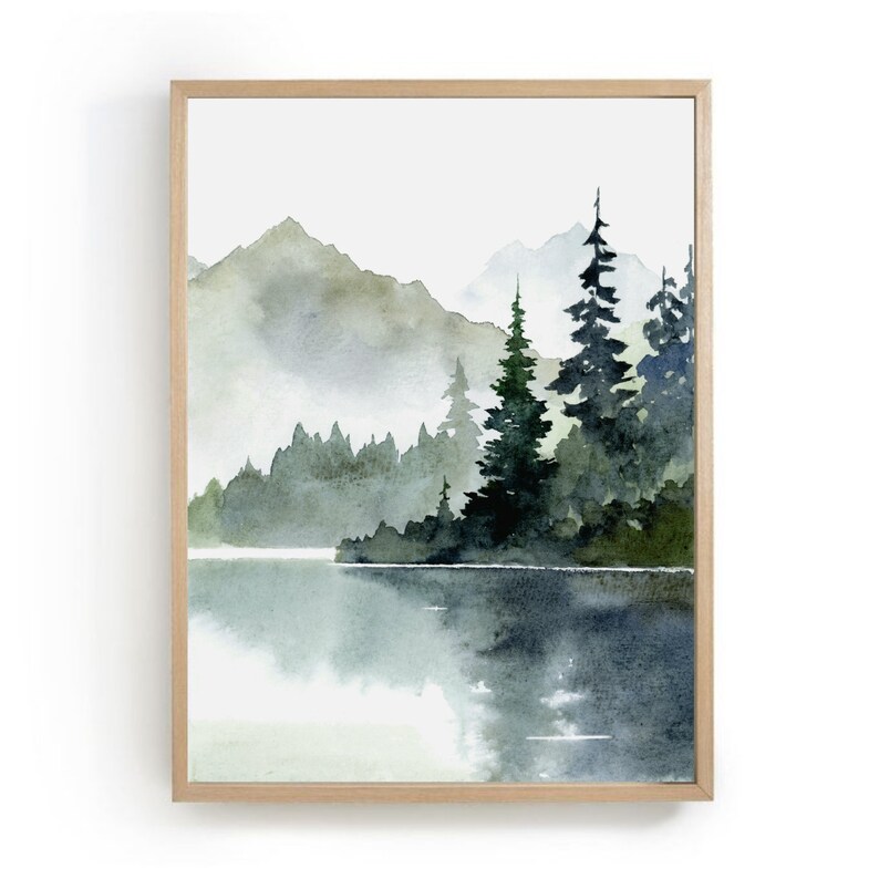 May include: A watercolor painting of a misty mountain landscape with a lake in the foreground. The mountains are a muted green and brown, and the lake is a soft blue. There are several dark green trees in the foreground, and the sky is a light gray.
