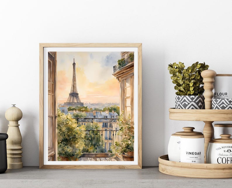 K&ouml;nnte beinhalten: Aquarellgem&auml;lde eines Pariser Balkons mit Blick auf den Eiffelturm. Das Gem&auml;lde ist in einem hellen Holzrahmen gerahmt und vor einer wei&szlig;en Wand platziert.