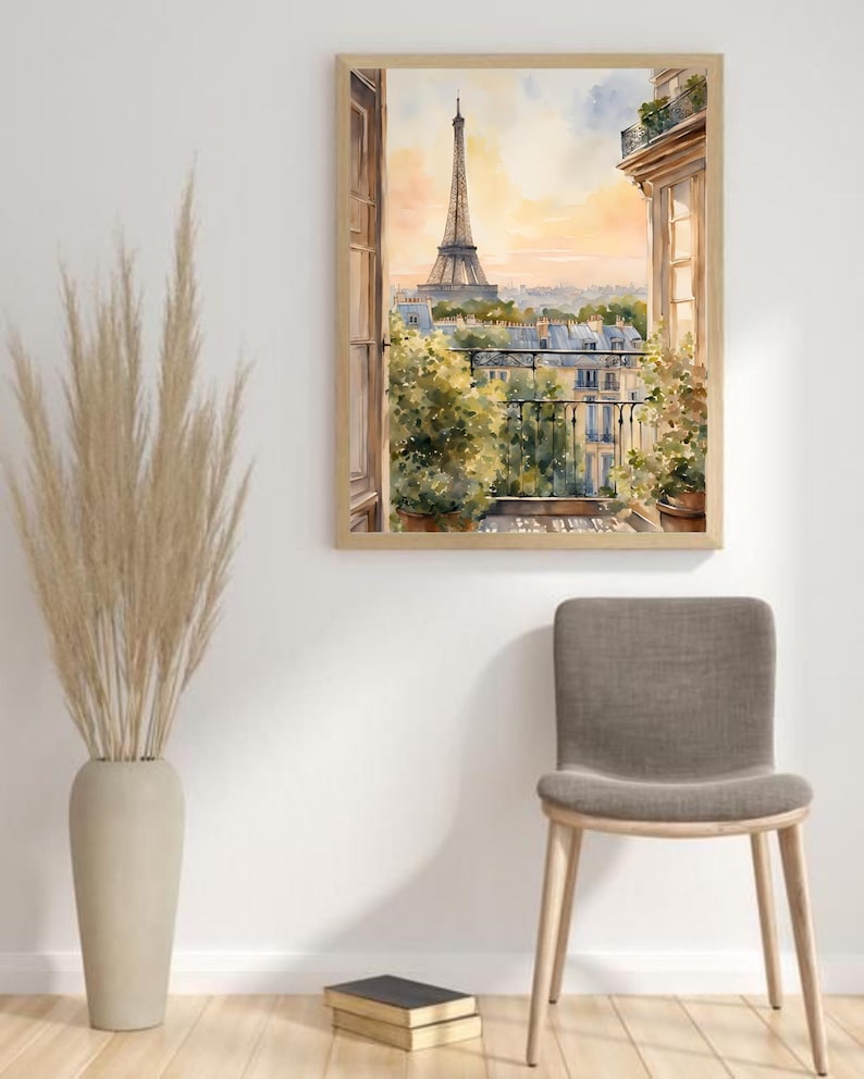 K&ouml;nnte beinhalten: Ein Aquarellbild eines Pariser Balkons mit Blick auf den Eiffelturm. Das Bild ist in einem hellen Holzrahmen gerahmt und h&auml;ngt an einer wei&szlig;en Wand.