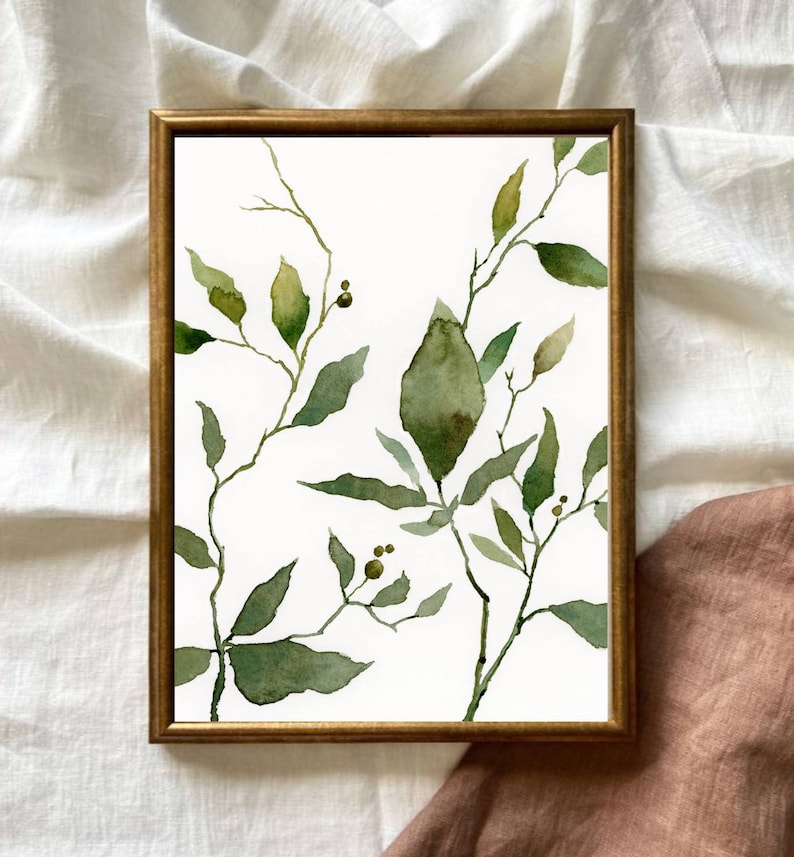 Puede incluir: Una pintura de acuarela enmarcada de hojas verdes y ramas sobre un fondo blanco. Las hojas est&aacute;n pintadas en un estilo suelto y abstracto, y las ramas son delgadas y delicadas.