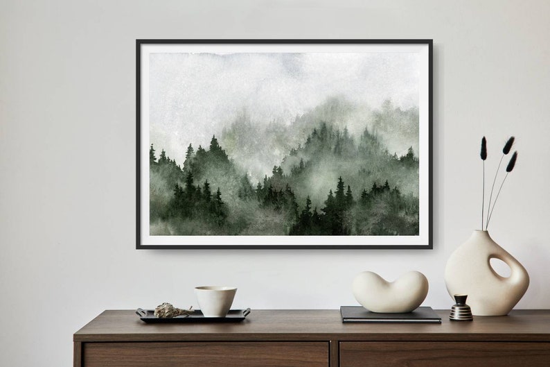 May include: A framed watercolour painting of a misty forest scene with green trees and a white background.