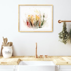 K&ouml;nnte beinhalten: Ein Aquarellbild eines Feldes mit Wildblumen in Gelb-, Orange-, Rot- und Gr&uuml;nt&ouml;nen. Das Bild ist in einem hellen Holzrahmen gerahmt und h&auml;ngt an einer wei&szlig;en Wand.