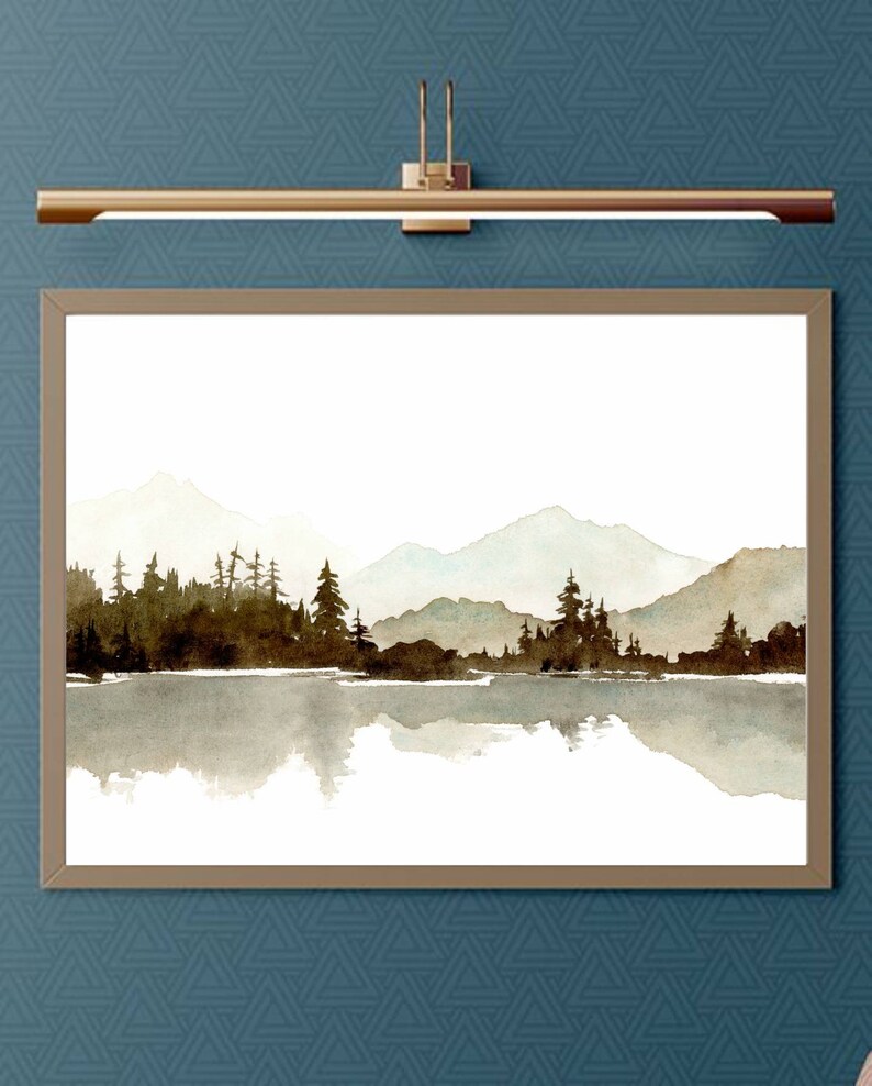May include: A watercolour painting depicting a mountain lake scene with a forest of trees reflected in the water. The mountains are in the background and are painted in shades of blue and grey. The trees are in the foreground and are painted in shades of brown and green.