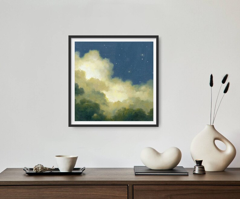 May include: A framed painting of a night sky with clouds and stars. The clouds are a light yellow and the sky is a dark blue. The stars are white.
