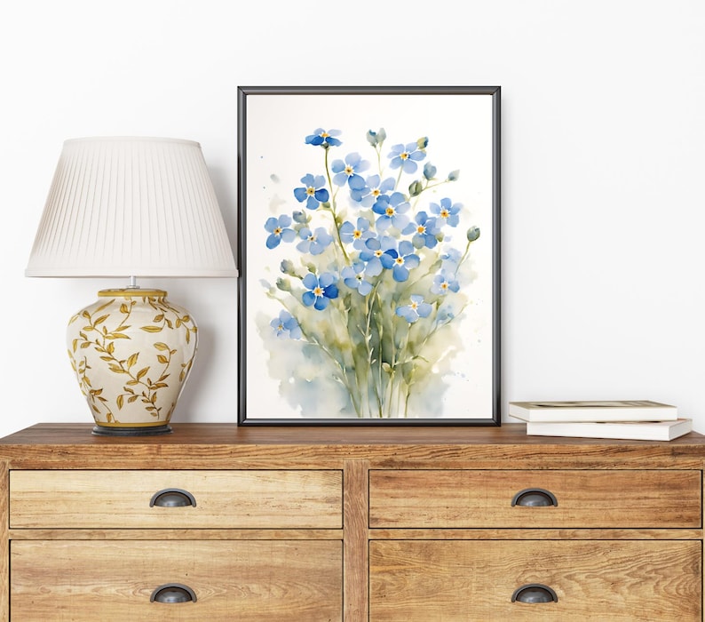 May include: A framed watercolour painting of a bouquet of blue forget-me-not flowers with green stems and leaves. The flowers are painted in a realistic style with delicate brushstrokes.