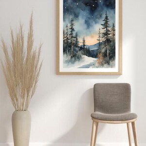 May include: A watercolor painting of a snowy forest scene with tall pine trees and a starry night sky. The painting is framed in a light wood frame and hangs on a white wall.