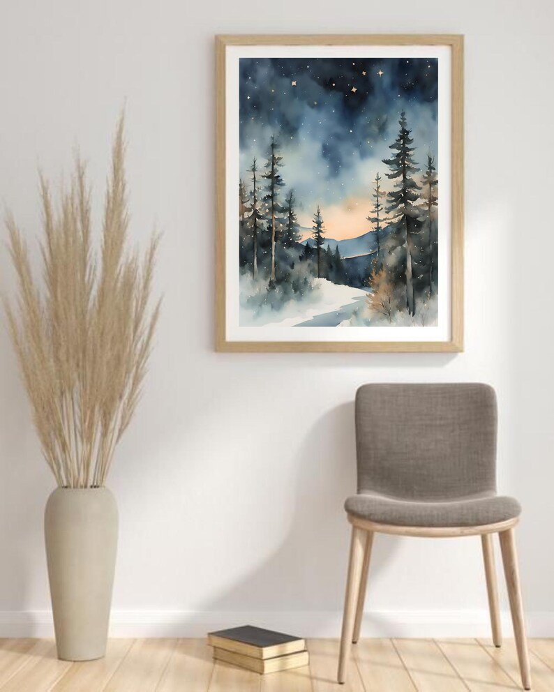 May include: A watercolor painting of a snowy forest scene with tall pine trees and a starry night sky. The painting is framed in a light wood frame and hangs on a white wall.