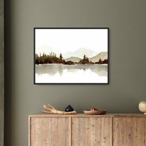 May include: A watercolour painting of a mountain range reflected in a lake. The mountains are a light brown colour and the lake is a light blue colour. The trees are a dark green colour and are silhouetted against the mountains.