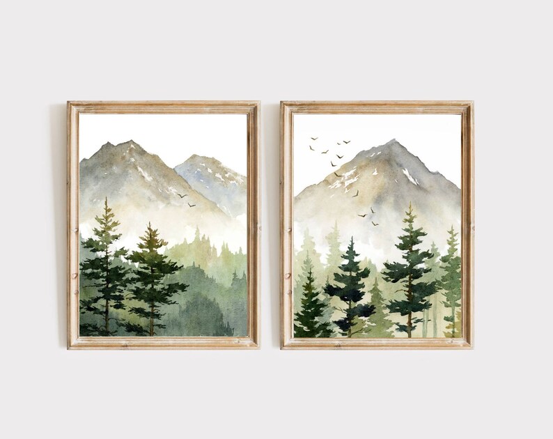 Puede incluir: Dos pinturas de acuarela enmarcadas de una cordillera con un bosque en primer plano. Las monta&ntilde;as est&aacute;n pintadas en tonos de gris y marr&oacute;n, mientras que el bosque est&aacute; pintado en tonos de verde. Hay p&aacute;jaros volando en el cielo sobre las monta&ntilde;as.