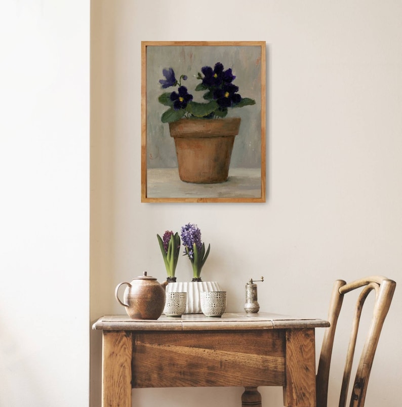 May include: A painting of a potted plant with purple flowers. The plant is in a terracotta pot and is sitting on a table. The background is a light gray color.