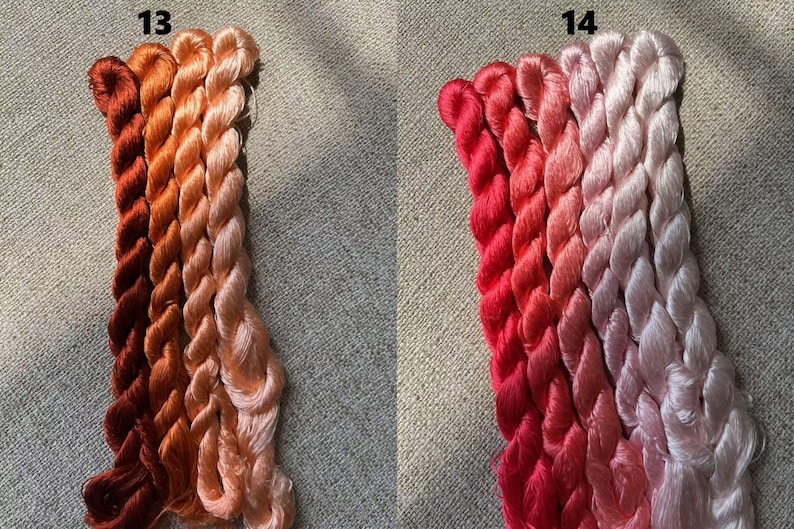 Pode incluir: Dois conjuntos de fio para bordar, cada um com quatro fios em um degrad&ecirc; de cores. O primeiro conjunto &eacute; etiquetado como "13" e apresenta tons de laranja e p&ecirc;ssego. O segundo conjunto &eacute; etiquetado como "14" e apresenta tons de vermelho e rosa.