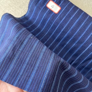 May include: Blue and white striped fabric with a label that says "#4 58cm in width".