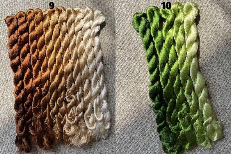 Pode incluir: Dois conjuntos de fio de bordado, um conjunto em tons de marrom e bege, e o outro em tons de verde e branco. O fio &eacute; organizado em feixes, cada feixe cont&eacute;m v&aacute;rios fios de fio.