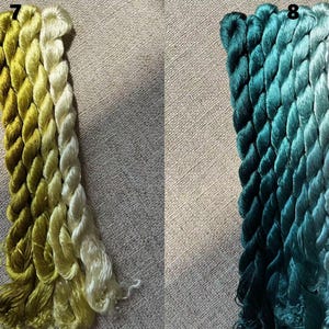 Pode incluir: Dois conjuntos de fio para bordar, um em tons de verde e amarelo, e o outro em tons de azul-esverdeado e azul. O fio est&aacute; disposto em um padr&atilde;o de degrad&ecirc;, com os tons mais escuros na parte inferior e os tons mais claros na parte superior. O fio est&aacute; etiquetado com os n&uacute;meros 7 e 8.