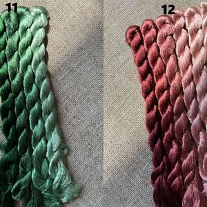 Pode incluir: Quatro novelos de fio para bordar em tons de verde, etiquetados com "11", e quatro novelos de fio para bordar em tons de rosa, etiquetados com "12".