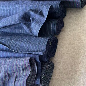 May include: A stack of blue and white striped fabric rolls. The fabric has a subtle shimmer and is perfect for crafting or sewing projects.