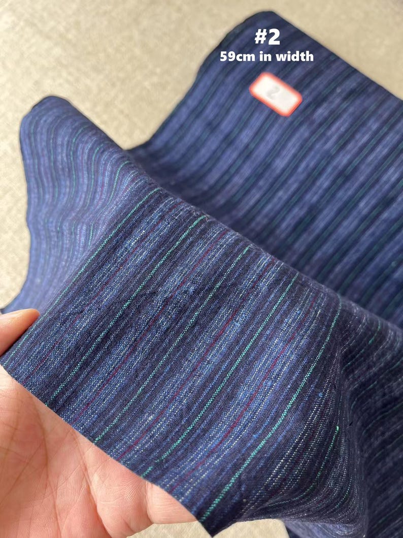 May include: A close-up of a blue and white striped fabric with a label that says "#2 59cm in width".