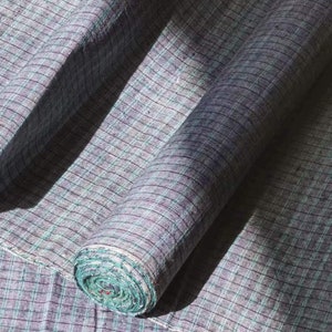 May include: A roll of blue and green checkered fabric. The fabric is woven with a fine, textured pattern.