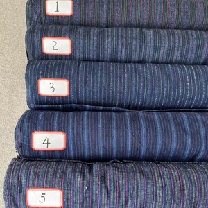 May include: Five rolls of striped fabric in various shades of blue, green, and red. The fabric is labeled with numbers 1 through 5.
