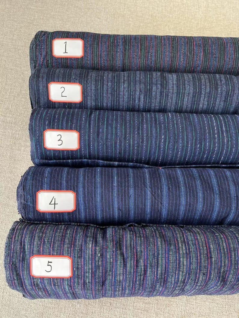 May include: Five rolls of striped fabric in various shades of blue, green, and red. The fabric is labeled with numbers 1 through 5.
