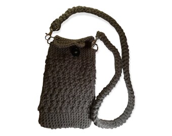 May include: A grey crocheted crossbody bag with a black button closure and a long adjustable strap.