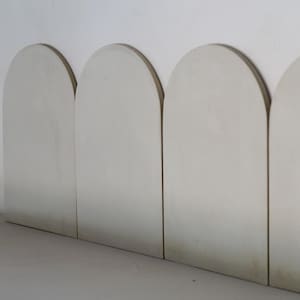 Może przedstawiać: Cztery białe ceramiczne płytki w kształcie łuku ułożone poziomo. Płytki są gładkie i mają lekko fakturowaną powierzchnię.