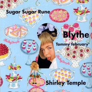 May include: A magazine cover featuring a doll with a keyhole revealing a young girl's face. The magazine is titled "Dollybird" and features a colorful background with a pattern of cupcakes, pastries, and strawberries. The text "Sugar Sugar Rune" and "Blythe Tommy february" are also visible.