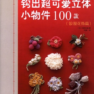 Può includere: Una copertina di libro con il titolo "crochet corsage pattern" in inglese e giapponese. La copertina presenta uno sfondo rosso con vari fiori all'uncinetto e altri piccoli oggetti.