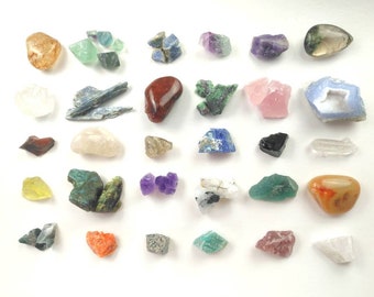 May include: A collection of 30 different types of crystals and gemstones, including amethyst, rose quartz, clear quartz, and more. The crystals are arranged in rows on a white background.